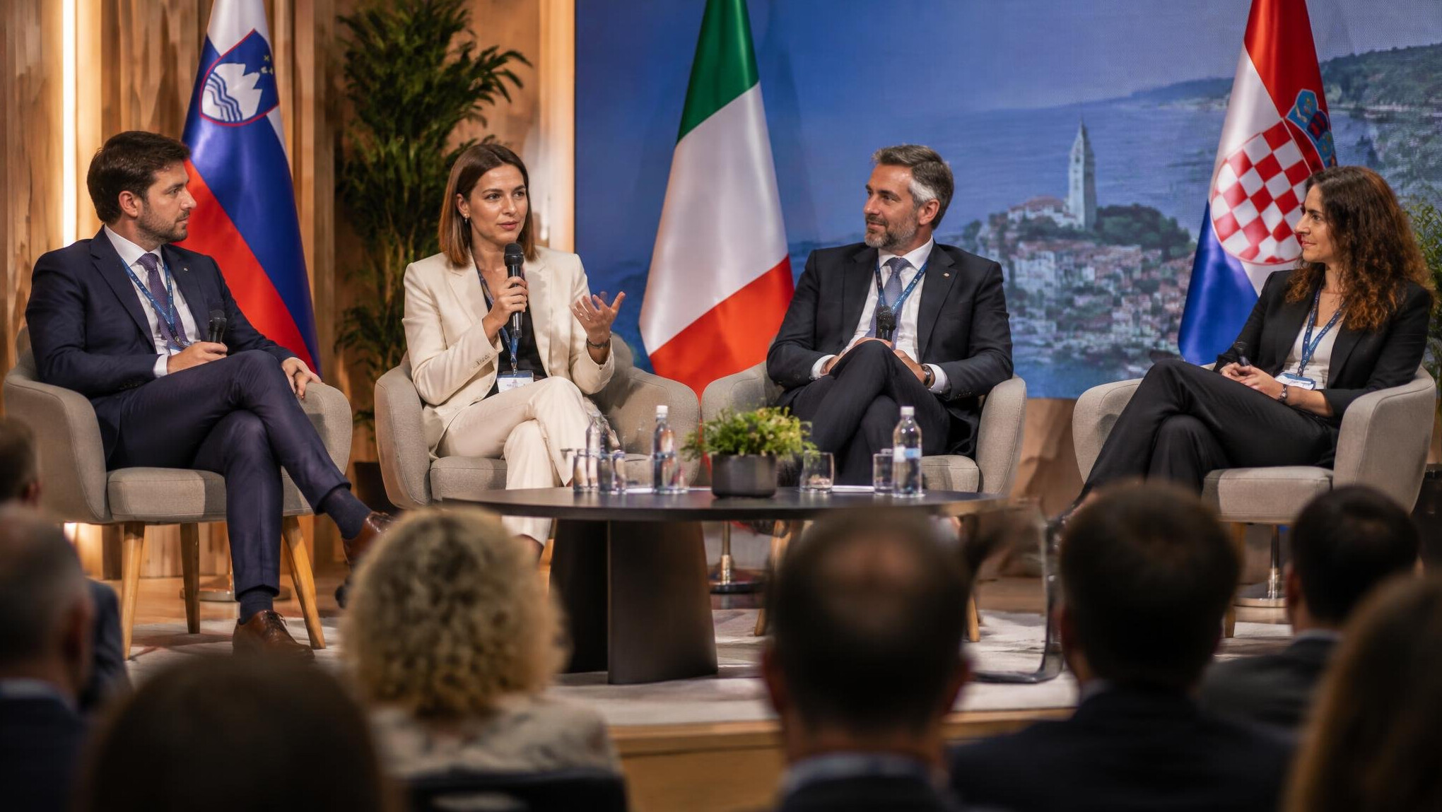 Panel discussion on stage with experts speaking into microphones